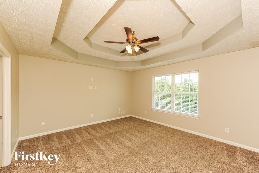 the living room of an empty house with a ceiling fan