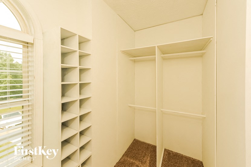a walk in closet with shelves and a window