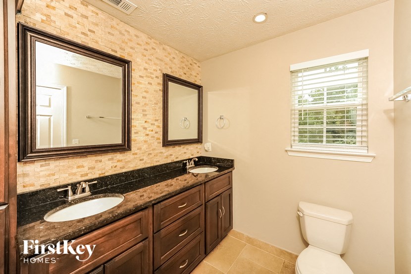 a bathroom with two sinks and a toilet
