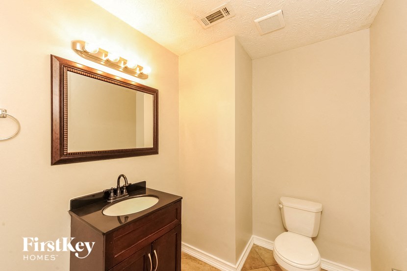 a bathroom with a toilet and a sink and a mirror