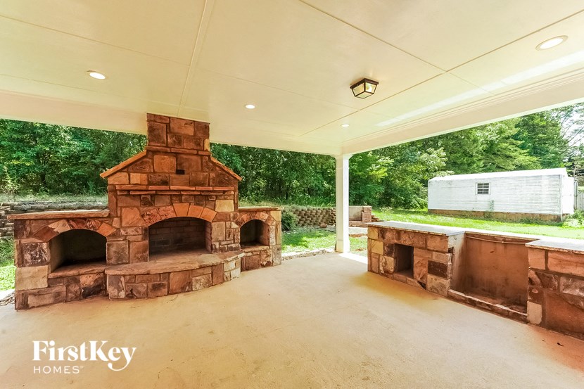 a covered patio with a fireplace and a bar