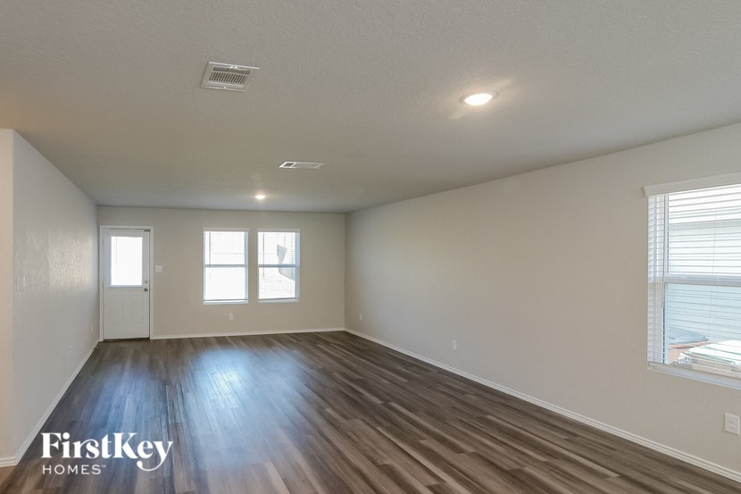 an empty living room with wood floors and white walls