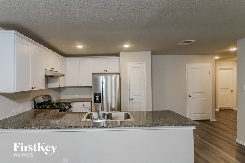 a kitchen with white cabinets and a granite counter top