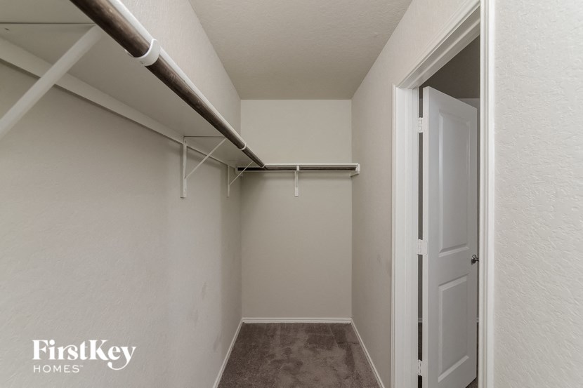 a walk in closet with white walls and a white door