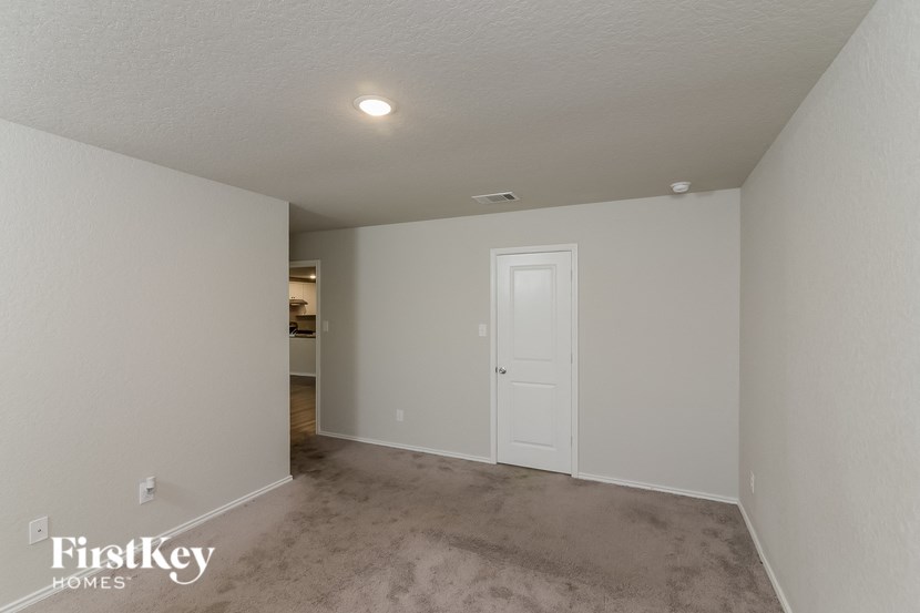 a bedroom with a white door and a carpeted floor