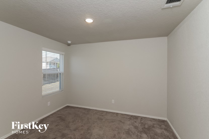 a bedroom with a carpeted floor and a window