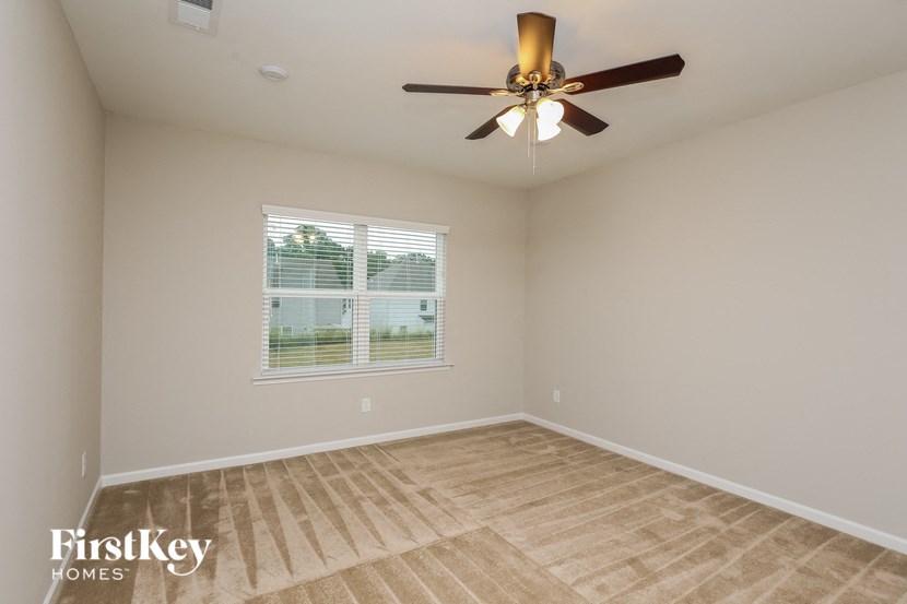 a living room with a ceiling fan and a window