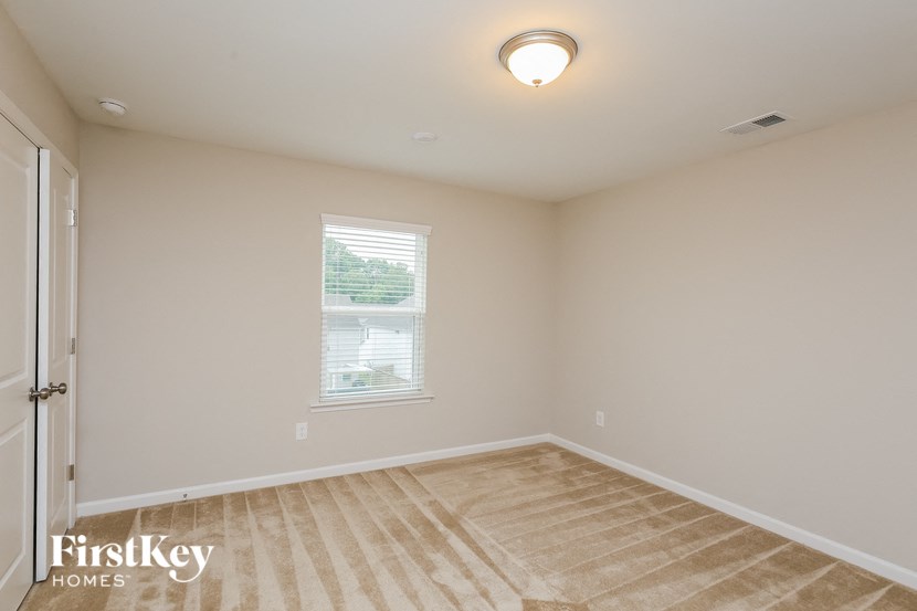 a bedroom with white walls and a white door and a window