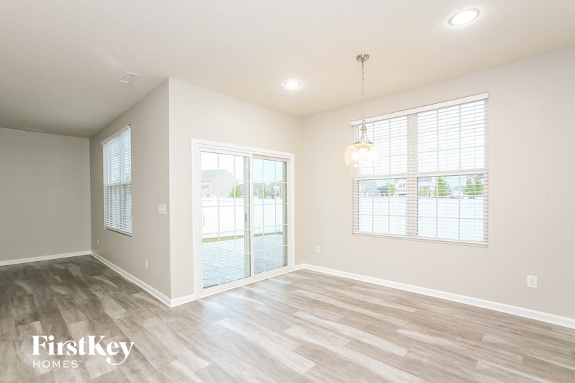 the living room of a new home with wood flooring and a large window