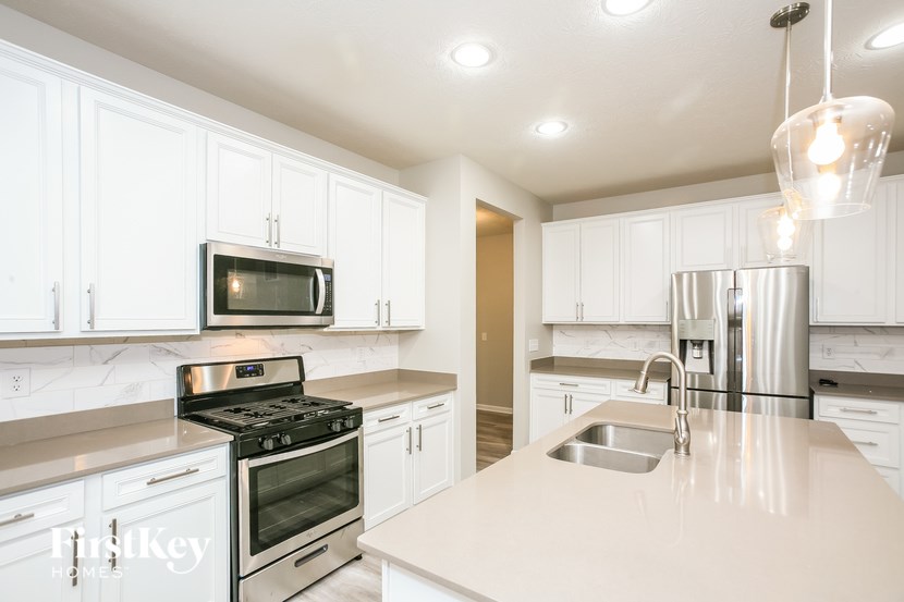 a white kitchen with stainless steel appliances and white cabinets