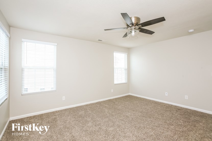 a room with carpet and a ceiling fan