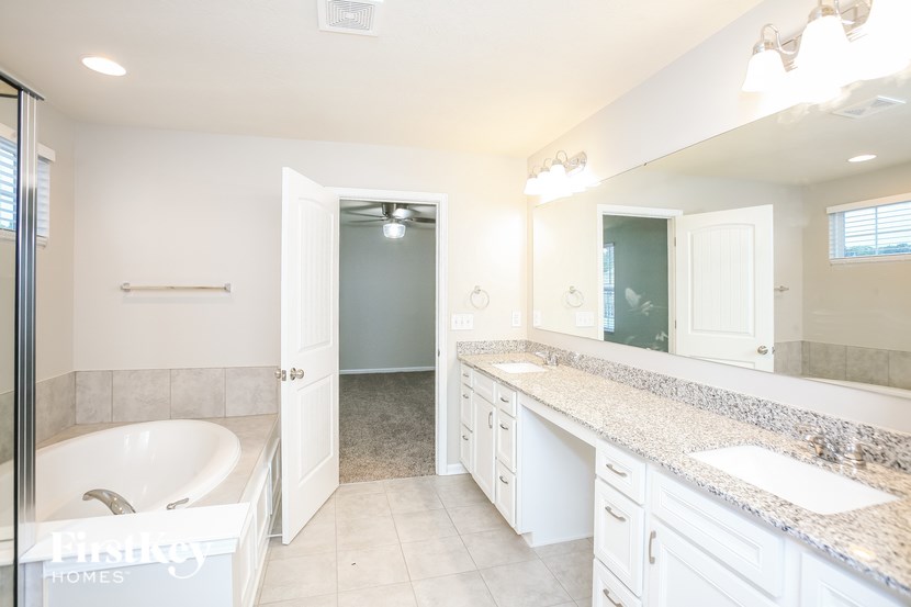 a bathroom with a tub and a sink and a mirror
