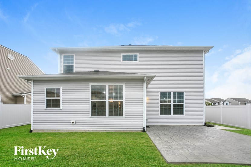 a white house with white siding and a grass yard