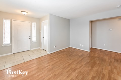 the living room and dining room with wood flooring and a white door
