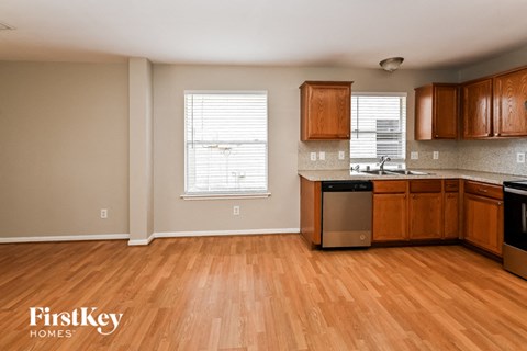 an empty kitchen with wooden floors and wooden cabinets