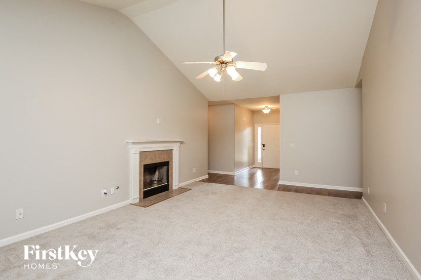 a living room with a fireplace and a ceiling fan