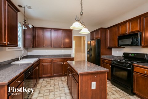 a kitchen with wooden cabinets and black appliances