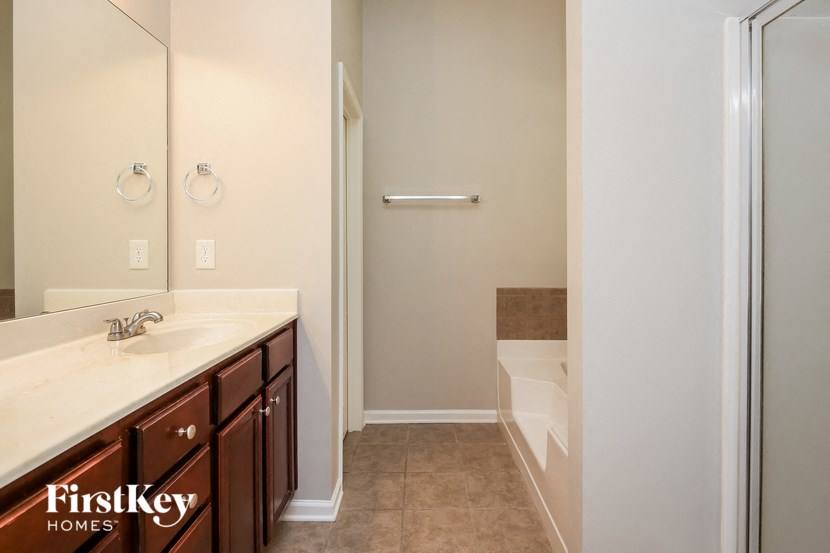 a bathroom with a shower and a sink and a mirror
