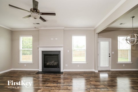 A modern living room with a fireplace and a ceiling fan.