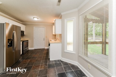A kitchen with a refrigerator, microwave, and oven.