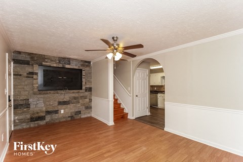 a living room with a stone wall and a ceiling fan