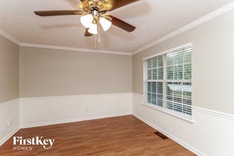 a bedroom with a ceiling fan and a window