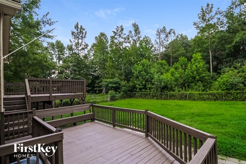 a large deck overlooking a lush green lawn and trees