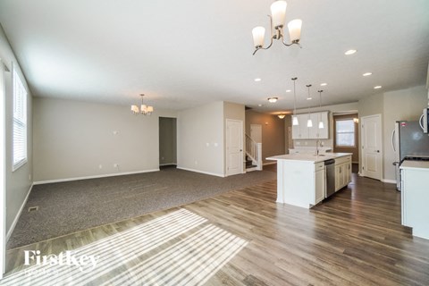 an open kitchen and living room with a kitchen island and rug