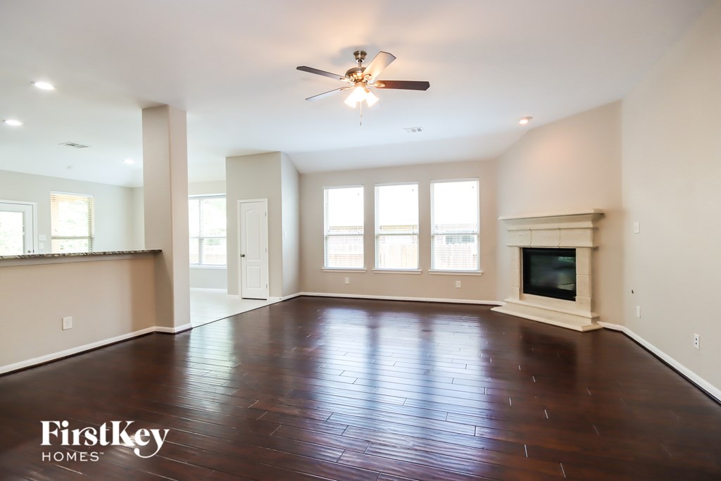 A spacious room with a fireplace and a ceiling fan.