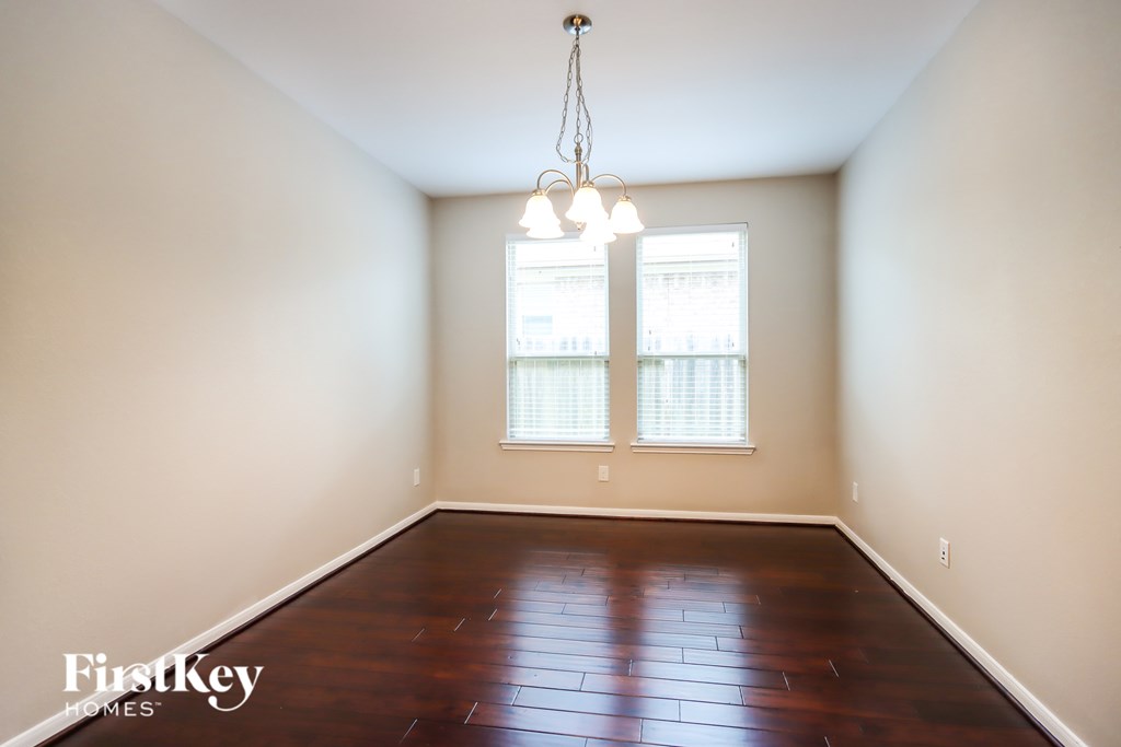 A room with a wooden floor and a chandelier.