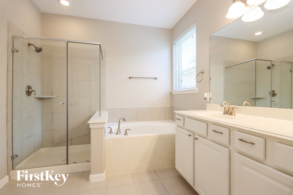 A white bathroom with a walk-in shower and a bathtub.