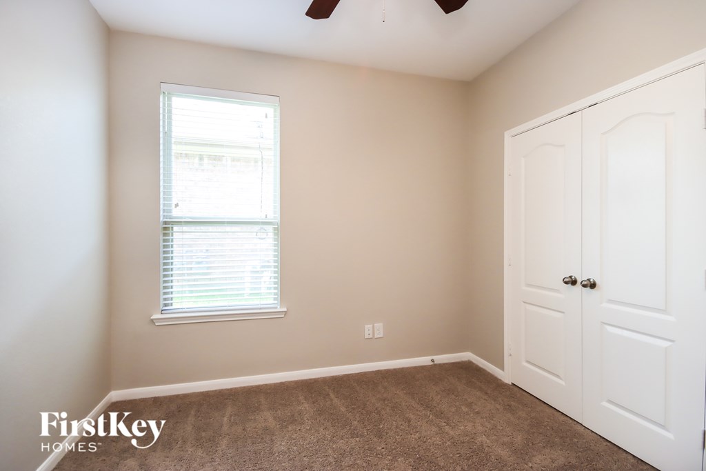 A room with a white door and a window with blinds.