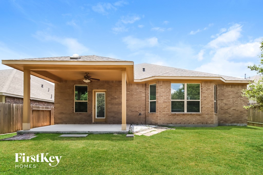 A house with a covered patio and a well-kept lawn.