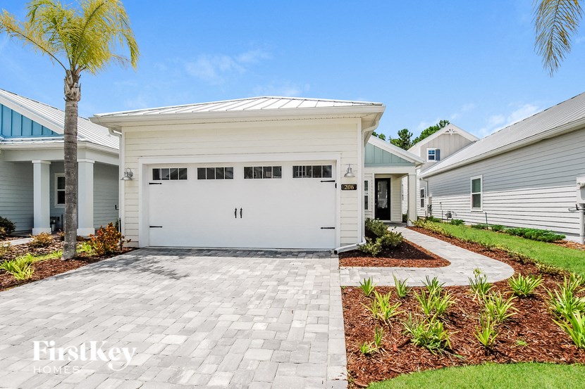 A white garage door is the centerpiece of this home's front yard.