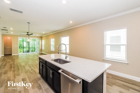 A modern kitchen with a large island and a stainless steel sink.