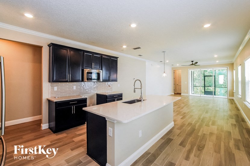 A kitchen with a white countertop and black cabinets.