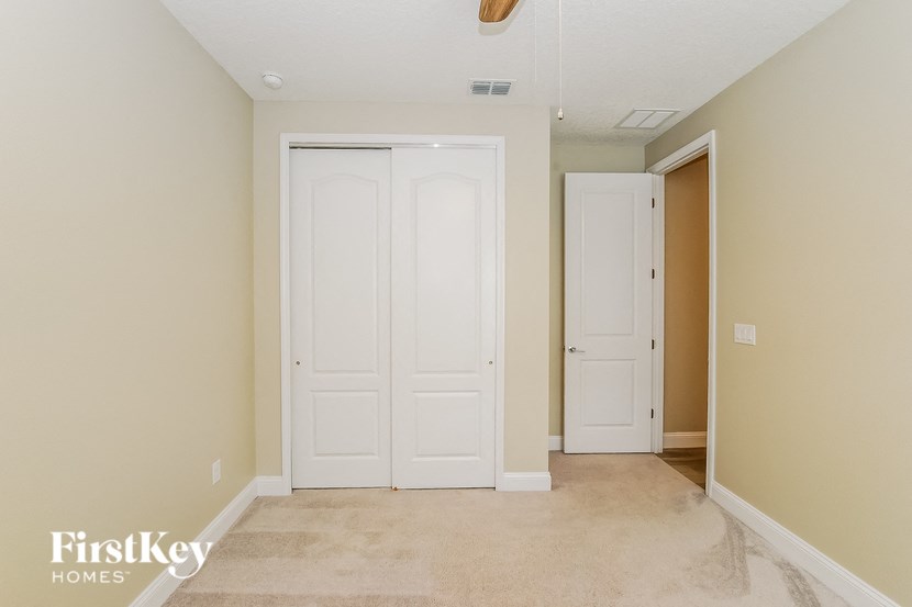 A room with two white doors and a carpeted floor.