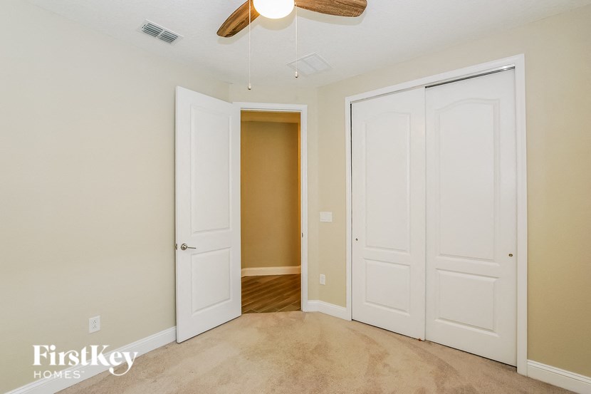 A room with a ceiling fan and two doors.