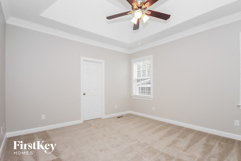 a empty room with a ceiling fan and a door