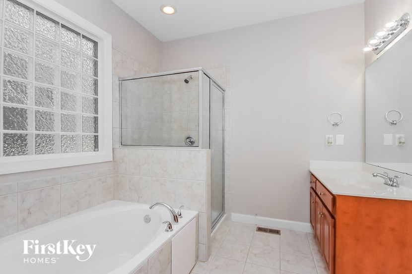 a bathroom with a tub and a shower and a sink
