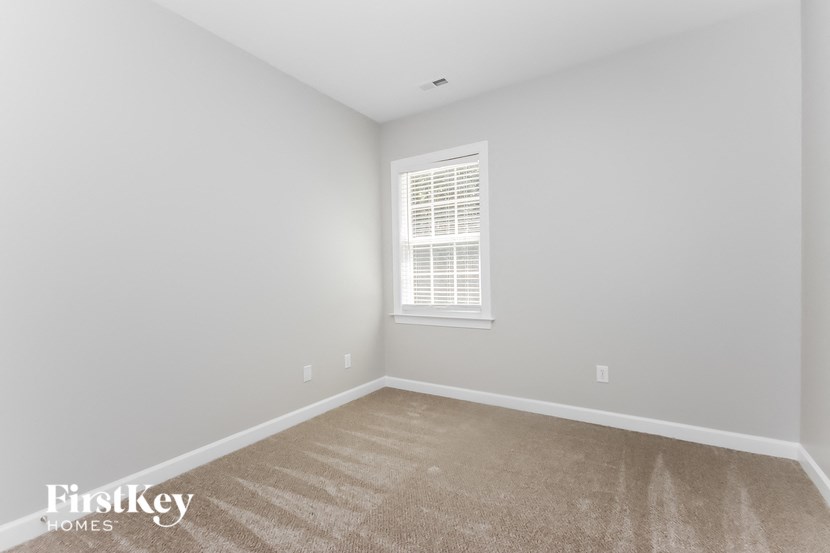 a bedroom with a carpeted floor and a window