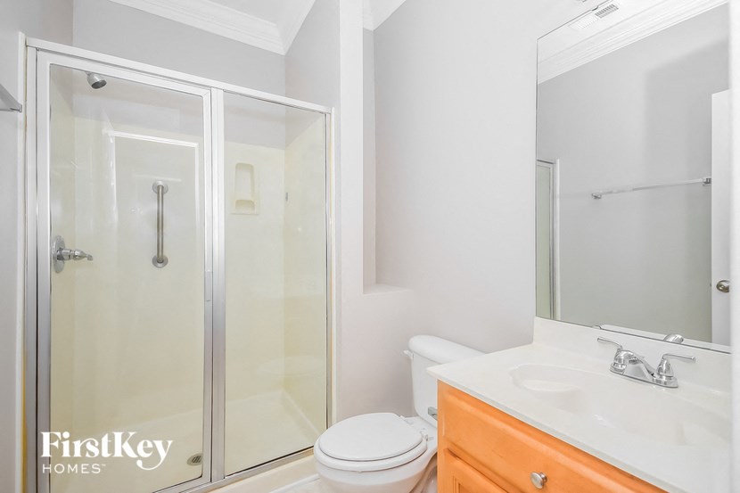 a white bathroom with a shower toilet and sink