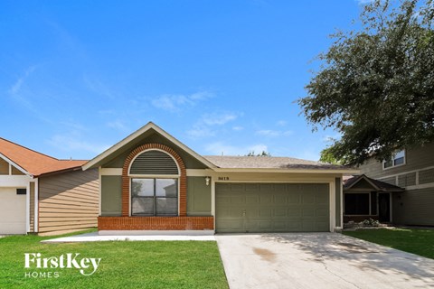 the front of a house with a driveway and a green garage door