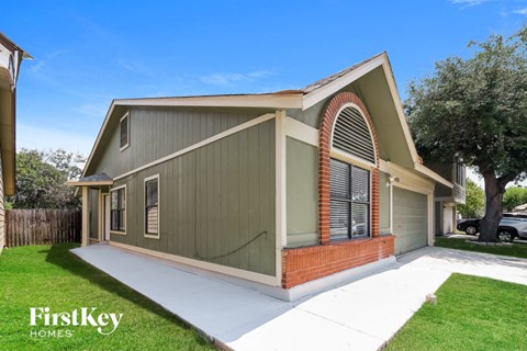 the exterior of a house with a driveway and a lawn