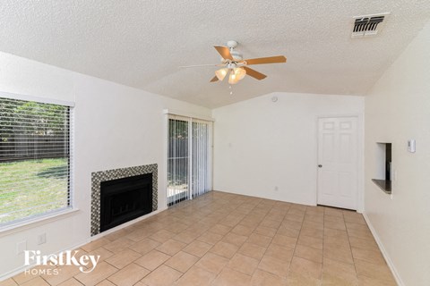 a living room with a fireplace and a ceiling fan