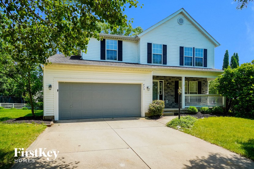 a white house with a gray garage door