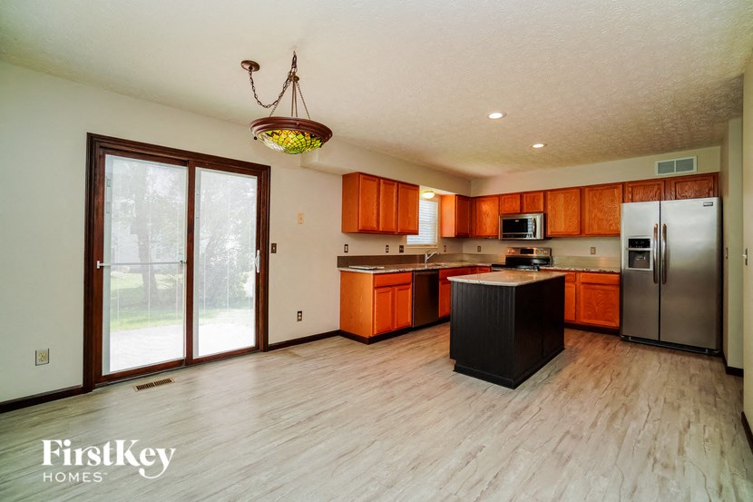 a large kitchen with wooden floors and stainless steel appliances