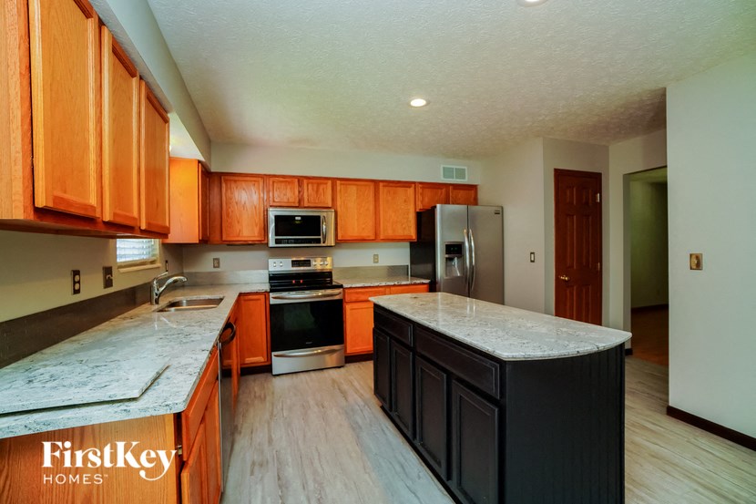 a kitchen with wooden cabinets and stainless steel appliances