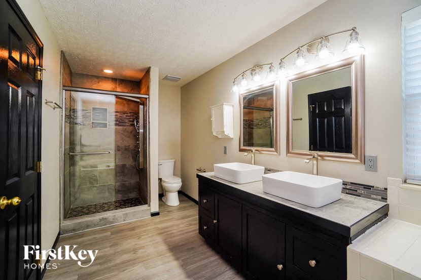 a bathroom with two sinks and a shower and a toilet