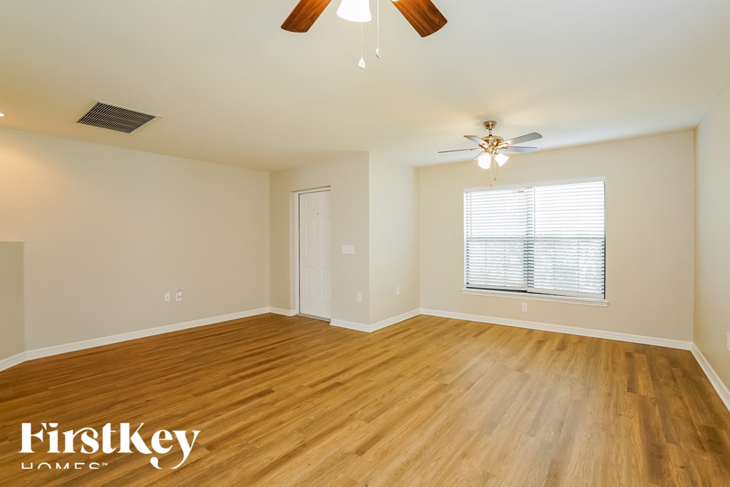 A room with wooden flooring and a ceiling fan.